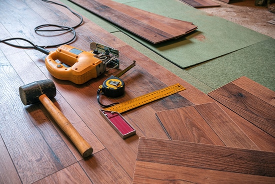 Mallet, tape measure, square, and other tools on a partly installed floor