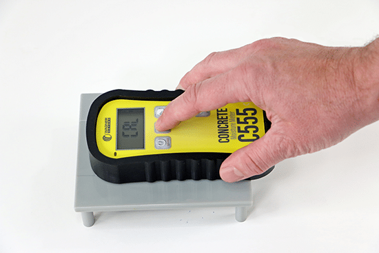 Someone places the C555 on its On-Demand Calibrator, demonstrating how this unique technology can prevent project delays